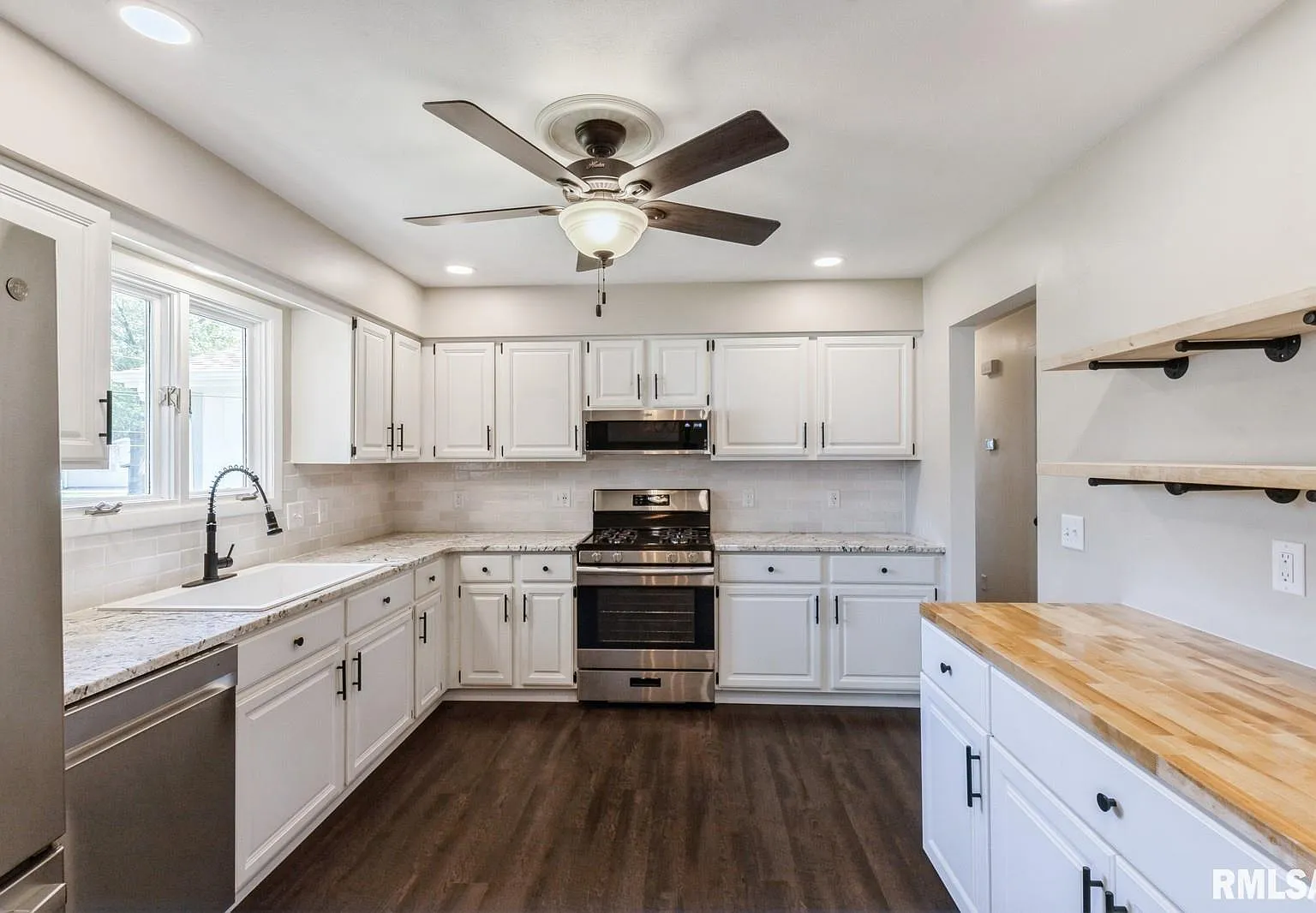 Modern kitchen renovation with white cabinets and granite countertops